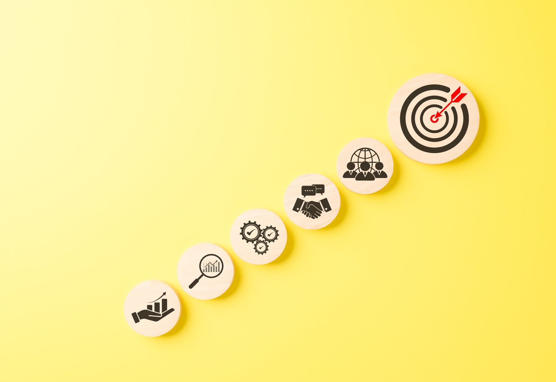 Business goals and target achievement concept. Icons arranged in rising toward bullseye target representing goal setting, growth, strategy execution, teamwork, successful business outcomes, objective,